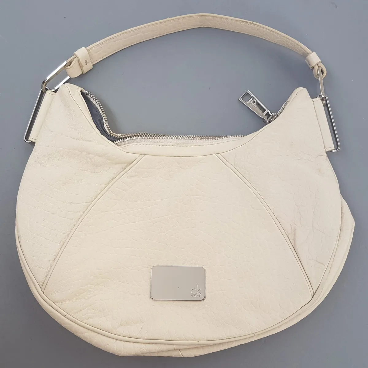 Original Calvin Klein Handbag, Cream Leather Hobo Bag, Crescent Silhouette, Signature CK Logo Plaque, Luxury Living, Haute Couture, Exquisite CK Shoulder Bag, Hand Carry, Cosmopolitan, Sophistication, Urban Style, Everyday Bag, Cult Street Fashion